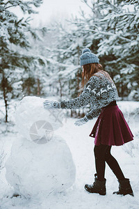 在户外堆雪人的女孩图片