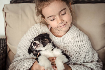 一个小女孩手里握着一只小狗宠物图片
