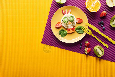 用紫色和橙色背景的餐具制成的食物制成的花式牛的盘图片
