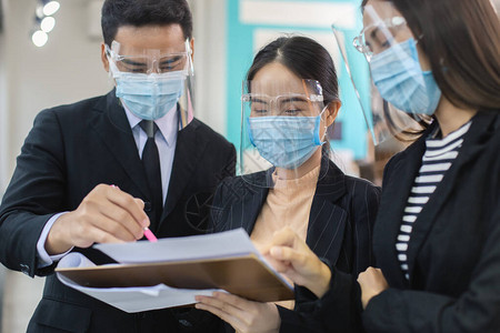亚洲商人戴着口罩和面罩防止空气传播疾病和唾液感染图片