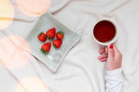 女孩喝咖啡吃草莓零食图片
