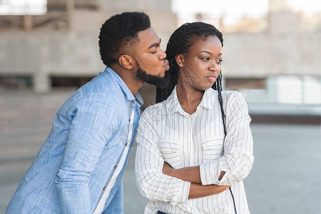 厌恶的Afro女孩拒绝她讨厌的男朋友的亲吻图片