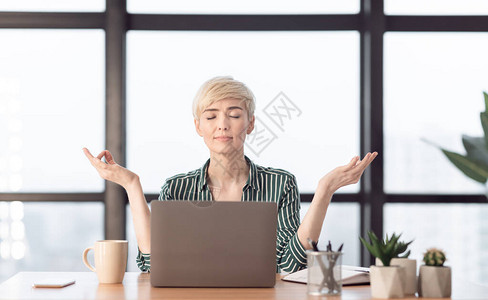 成熟的女商人在坐现代办公室的工作场所冥想放松冥想和工作压力缓解图片