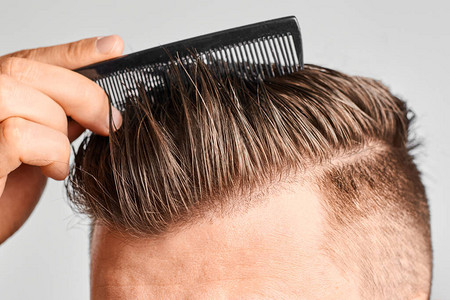 男人用塑料梳洗干净的头发图片