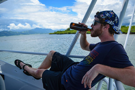 男人在船上喝啤酒图片