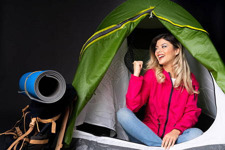 在一个露营的绿色帐篷里的少女图片