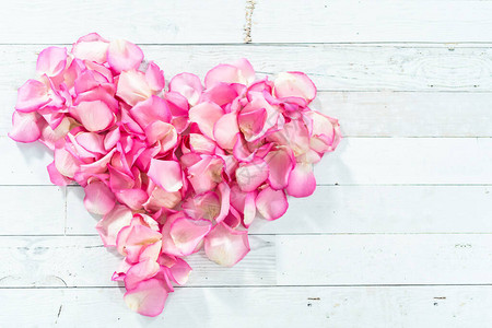 粉红色玫瑰花瓣的心脏形状画成白色木图片