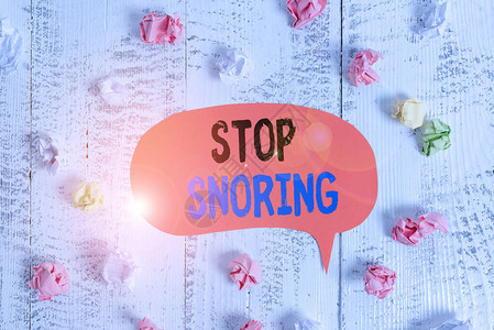 概念手写显示停止打鼾概念意味着由于气道组织振动而导致睡眠时呼吸嘈杂彩色语音气泡纸球木质背景图片