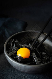 黑色面食与墨鱼水在黑色背景上的黑色盘子罕见的意大利海鲜酱意图片