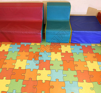在幼儿园用彩色拼图垫子的儿童使图片