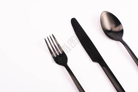 用白色隔开的刀叉和勺子的顶视图背景图片