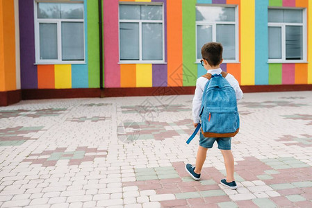 小男孩要回学校了第一个上学日背着书包和书本的孩子后视图学校理图片