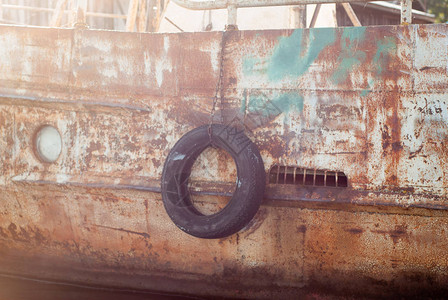 码头旧船上的黑色轮胎特写图片