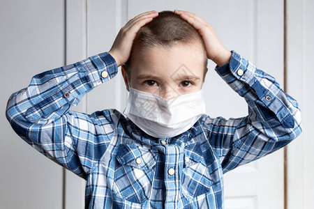 戴着医用口罩眼睛酸痛的小男孩看着相机对空气传播疾病头孢的医疗保护希尔图片