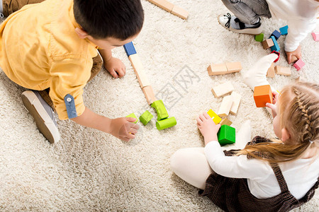 孩子们在地毯上玩木块的俯视图背景图片