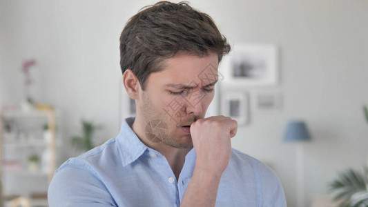 咳嗽生病的英俊年轻人在工作中咳嗽图片