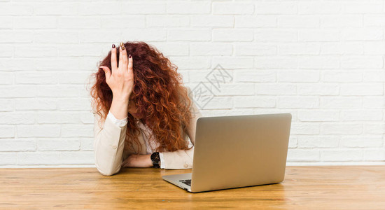 带着笔记本电脑工作的红发姑娘图片