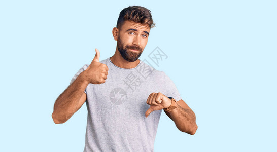 身着便衣的西班牙青年男子在上下伸起拇指持不同意见和协议表达看法图片