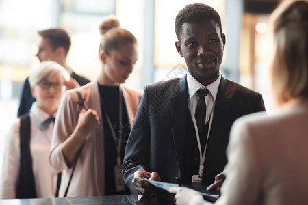靠近商业会议登记和注册的非洲青年商人在商业大会背景图片