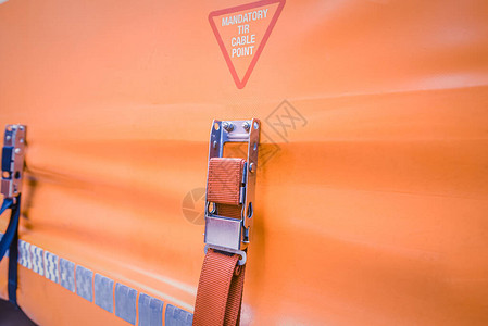 绳子系在橙色卡车窗帘上吊链带挂在了橘色背景图片