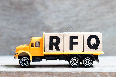 卡车在木材背景上持有用RFQ字写的字母块背景图片