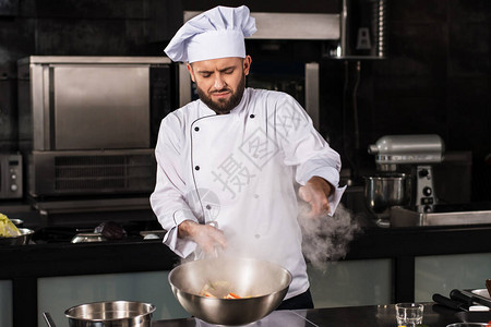 厨师在厨房餐厅搅拌食物厨师用炒锅准备亚洲食物穿制服的厨师在专业图片