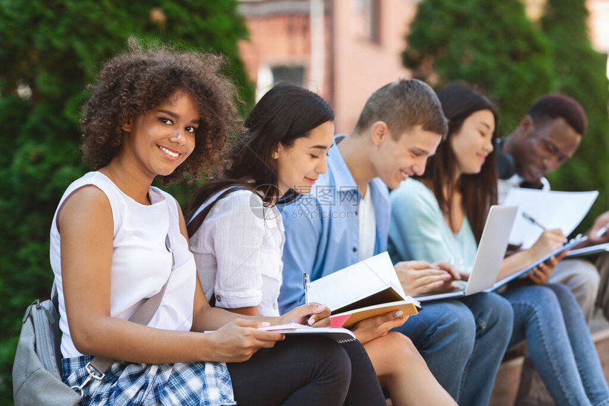 快乐的非裔美国女学生与她的大学友校共同准备户外考试图片