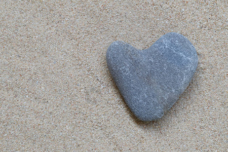 心形的沙石躺在沙子上图片
