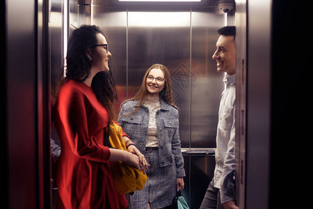 女孩和男孩乘坐电梯电梯里的学生去学习电梯里的人电梯与人图片