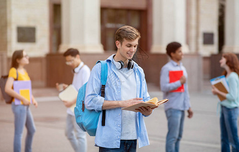 大学生家伙读书学习站在大学楼外获得学位图片