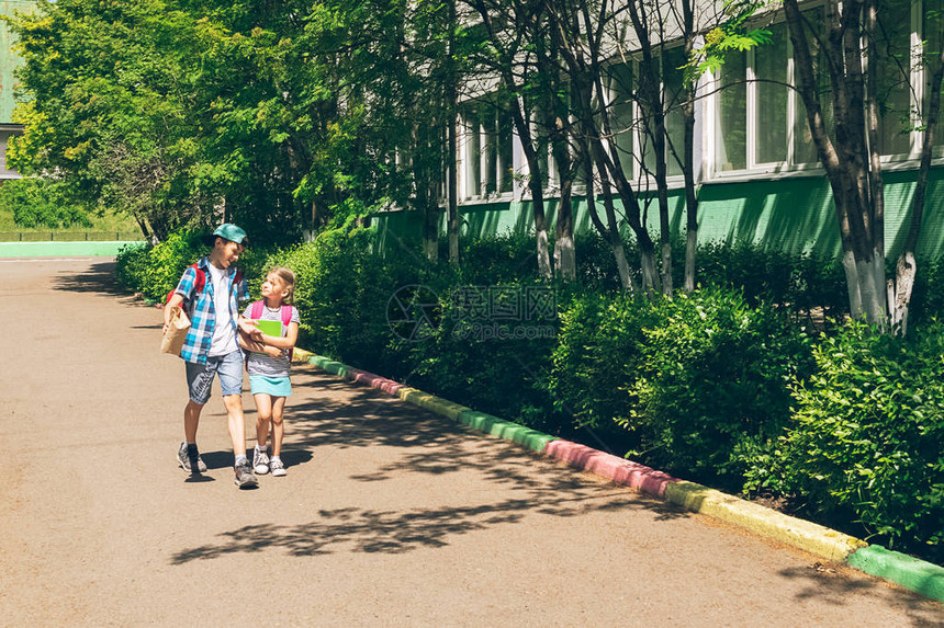 一个男孩和一个女孩的兄弟姐妹带着书包去上学水平框架选择焦点复制空图片