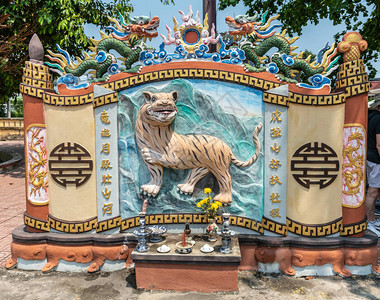 DinhPhuVinh社区中心和庆典厅蓝色天空下带有老虎壁画和龙雕的装饰蜜背景图片