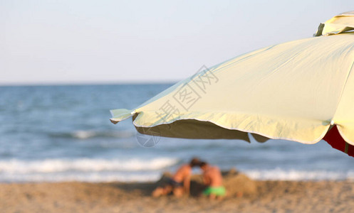 暑假在海滩和太阳伞上玩耍的孩图片