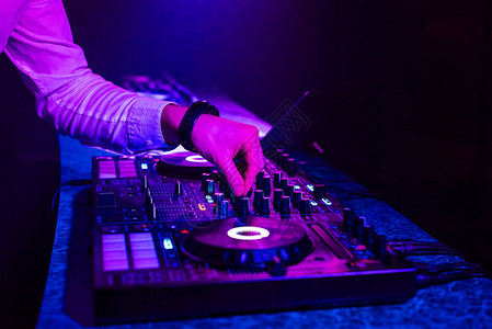 DJ在现场电子音乐会上与一个混音器控制器图片