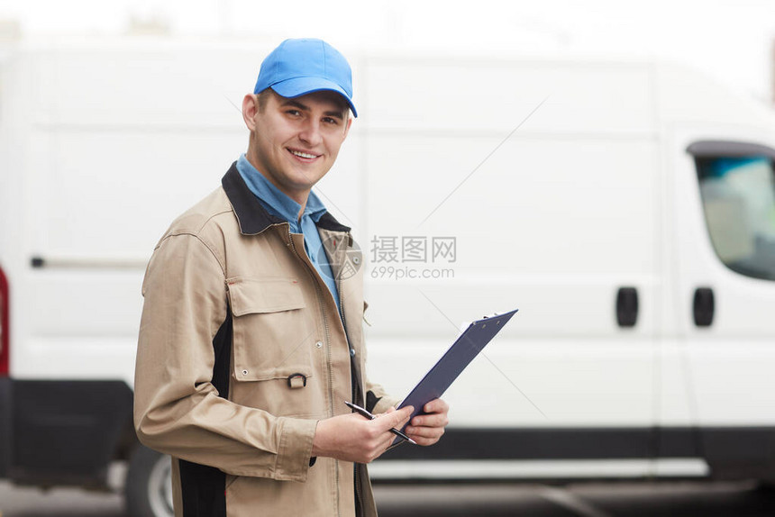 年轻男子在送货公司工作时站在户外的镜头下微笑