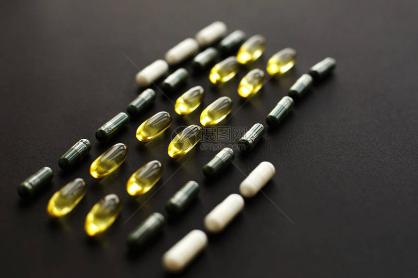 黑色深背景上的欧米茄3螺旋藻叶绿素镁胶囊膳食补充剂健康支持和治疗生图片