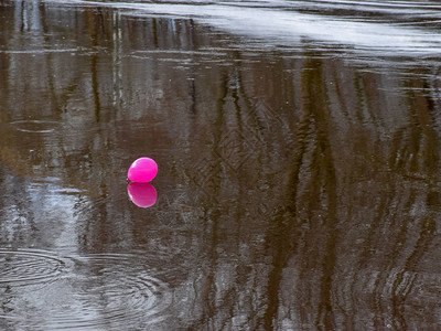 粉红色的气球在黑暗的奔流河中闪耀图片