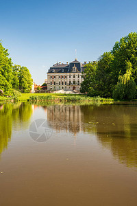 Pszczyna城堡在美丽的春日与晴朗的天空中映照在波兰的小湖水地上图片