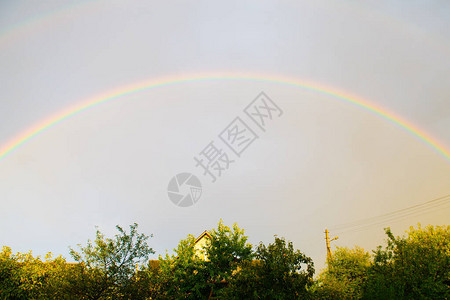 天空中的双彩虹雨后自然奇迹彩虹背景上的多云天空和平的象征图片