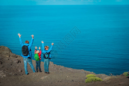 与父亲和儿子及女儿一起享受在靠近海洋的山区旅行家庭徒步出行在西班牙大图片