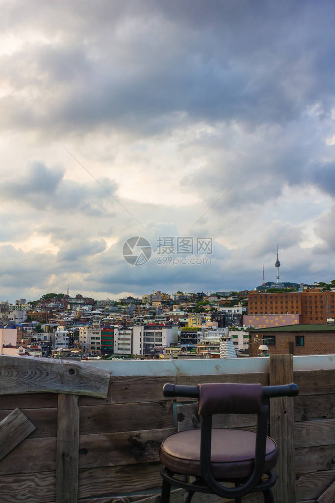 木制阳台上的城市景观前景是一把椅子雨前多云的天空单程冷静图片