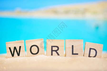 抽象的海滩沙子和海与词木立方体的世界世界旅游概念图片