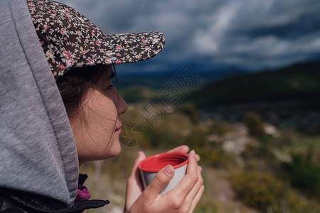 穿着帽子的旅游女孩拿着杯子图片