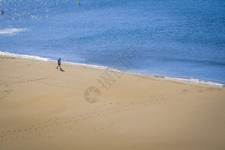 单身退休老人走在沙滩上图片