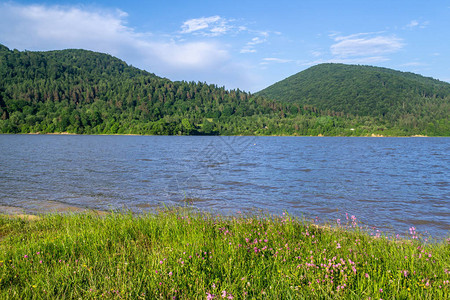 被群山和草地环绕的湖泊图片