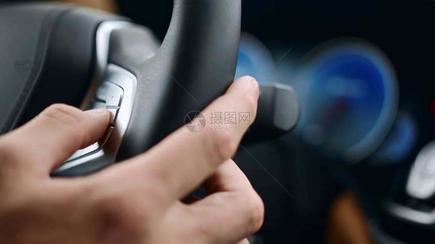关闭男手按方向盘上的按钮特写男人手指触摸汽车轮上的按钮在豪华车上使用车轮按钮的图片