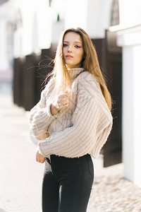 一个年轻美丽的时尚女孩的肖像穿着一件织着丝绸的美甲毛衣在欧洲城市图片