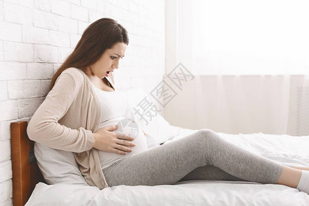 BraxtonHicks的收缩怀孕妇女在家中腹部疼痛侧图片