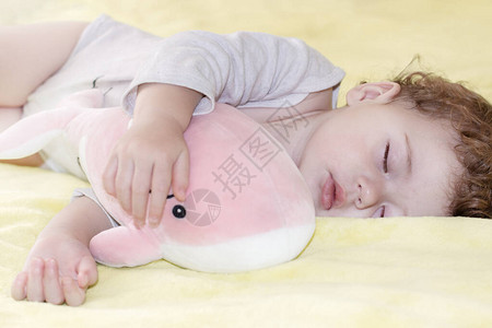 小女孩睡着的男孩抱着一只玩具粉红鲸鱼白种人小孩睡着一个毛绒玩具图片