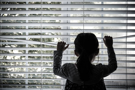 独孤幼儿童站在窗前看着高清图片